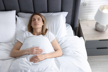 Woman snoring while sleeping in bed at home