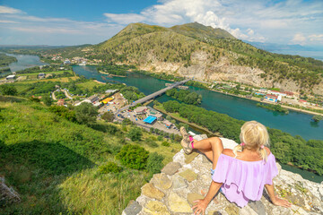 female tourist sitting at Rozafa Castle in Albania. The castle dates back to ancient times and has...