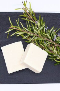 Pastillas de jab&oacute;n natural artesano con esencia de romero fresco, jab&oacute;n solido y natural aislado en fondo oscuro de piedra de pizarra