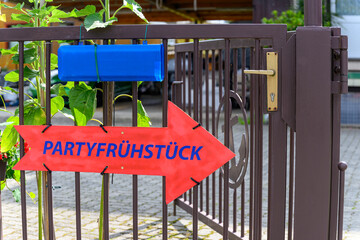 A signpost for breakfast on a fence in german language