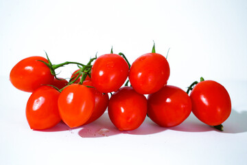 Bunch of red cherry tomatoes with a white background