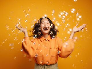 Asian woman enjoying the fresh feeling of bubbles, yellow background