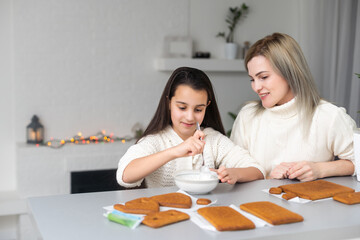 Fototapeta premium Icing of Christmas bakery. honey gingerbread cookies, ready to decorate.