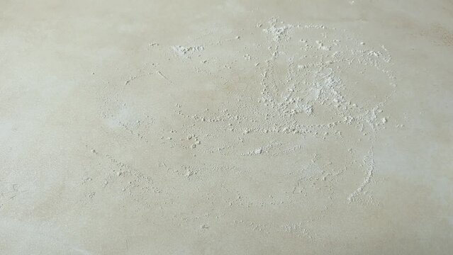 Dusting the table with flour and rolling out the dough for a pie, galette or cookies with a rolling pin, top view lifestyle horizontal video