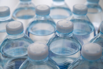 Transparent plastic bottles, containing water, next to each other. Use and recycling of plastic.
