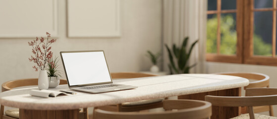 A blank screen laptop mockup on a table in a minimal Scandinavian room interior.