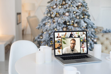 People on virtual call with family and friends exchanging gifts and celebrating virtual christmas online due to social distancing and coronavirus lockdown and quarantines. Image on computer screen.