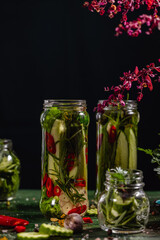 Canned cucumbers with home garden vegetables and herbs. Pickling fresh cucumbers after harvest.