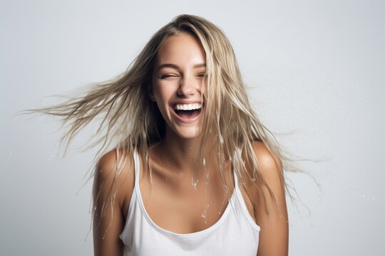 feamle model with wet hair smiling and shaking head