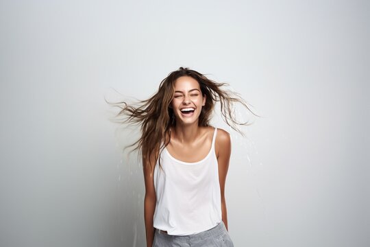 female model with brown hair wearing white tshirt and shaking wet hair