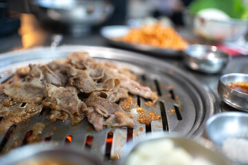 Close up of Korean grilled meat barbecue. Traditional Korean grilled meat as pork or beef was roasted or fired on stainless stove at Korean bbq restaurant. Asian and Korea traditional food concept. - 643957646
