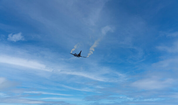 Drones and fighter jets performing a demonstration flight. In the blue sky