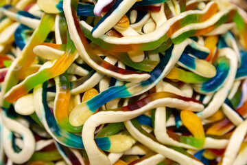Colorful jelly candies in the form of worms, candy background.
