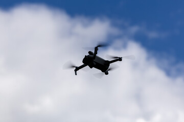 Fototapeta na wymiar drone hovering in a bright blue sky. New technology in the aero photo shooting.