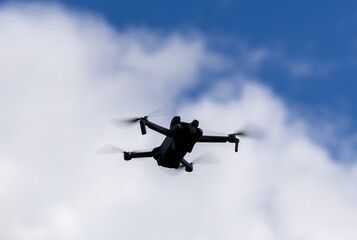 drone hovering in a bright blue sky. New technology in the aero photo shooting.