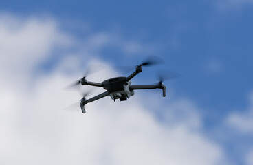 drone hovering in a bright blue sky. New technology in the aero photo shooting.