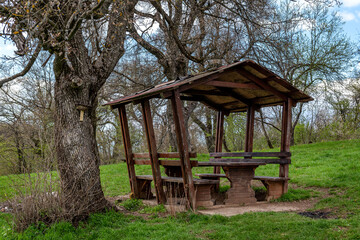 Picnic area with benches, table and sunshade in nature, top of the hill
