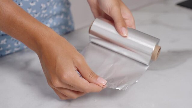 Girl holding a roll of food foil