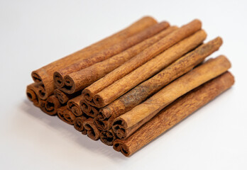 A close-up of a pile of vanilla sticks on a white background