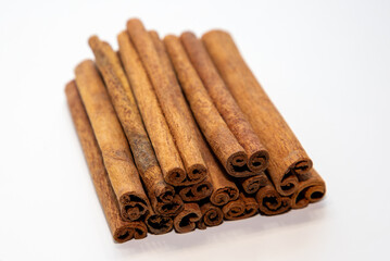 A close-up of a pile of vanilla sticks on a white background