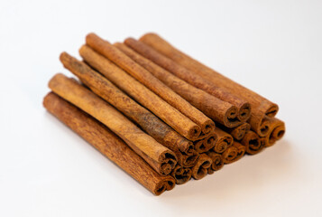 Many cinnamon sticks on a white background