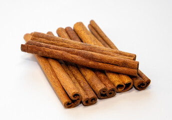 Many cinnamon sticks on a white background
