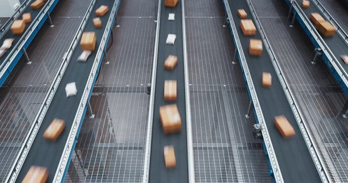 Top Down View of a Modern Automated Logistics Warehouse with Multiple Conveyor Belt Systems with Online Shopping Orders. Timelapse Footage of Parcels Transported on Conveyor Line