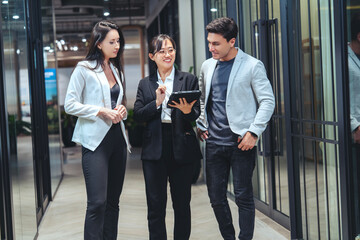 Group of employees with boss of many nationalities walking and talking, helping to think and...