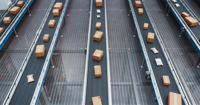 Top Down View with Multiple Conveyor Belt Systems Transporting a Range of Retail Orders from an Online Business Sales. Valuable Parcels Managed by a Modern Automated Logistics System in a Warehouse