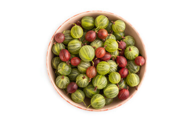 Fresh red and green gooseberry in ceramic bowl isolated on white, top view.