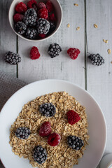 Oatmeal with berries. wooden on a white background. Breakfast