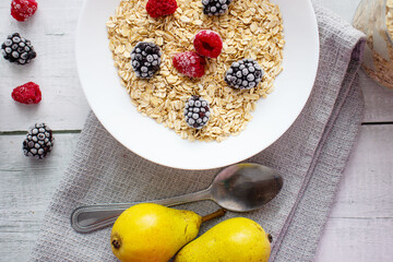 Oatmeal with berries. wooden on a white background. Breakfast