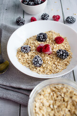 Oatmeal with berries. wooden on a white background. Breakfast
