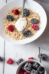 Oatmeal with berries. wooden on a white background. Breakfast