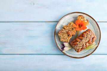 Caramel and almond cake on blue wooden, top view, copy space.