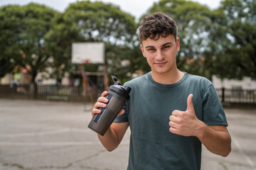 one young caucasian man teenager hold supplement shaker stand outdoor