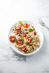 Warm couscous salad with tomatoes and red onion