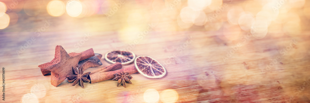 Wall mural Spices with dried orange and cinnamon on wooden background with blurred lights, christmas panoramic web banner - Wall murals