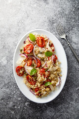 Warm couscous salad with tomatoes and red onion