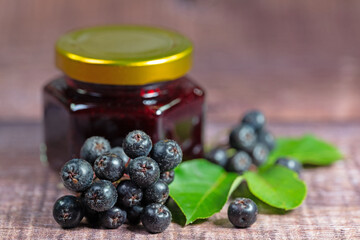 Aroniabeeren und Aronia-Marmelade im Schraubglas