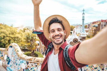 Happy tourist take selfie self-portrait with smartphone in Park Guell, Barcelona, Spain - Smiling man on vacation looking at camera - Holidays and travel concept - 643981865