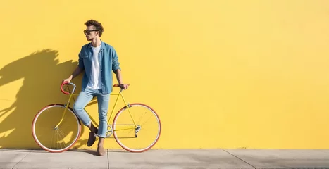Foto op Plexiglas Side view of a young hipster man with a fixed bike near the yellow wall © kilimanjaro 