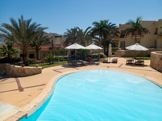 Beautiful view of the Egyptian hotel with palm trees, flowers and a swimming pool
