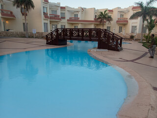 Beautiful view of the Egyptian hotel with palm trees, flowers and a swimming pool