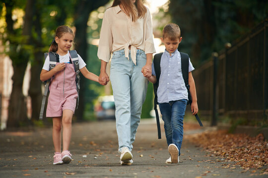 Holding Hands, Walking Together. Woman With Two Kids Are Going To School, Conception Of Education