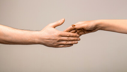 Mercy, two hands, connection or help concept. Finger touching hands man woman gray background...