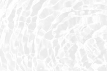 White water with ripples on the surface. Defocus blurred transparent white colored clear calm water surface texture with splashes and bubbles. Water waves with shining pattern texture background.