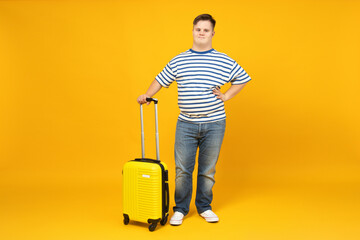 Smiling young man with down syndrome in glasses with suitcase