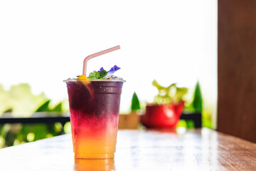 Butterfly pea or blue pea juice ice cool drink with lime on wooden table.