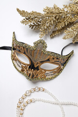 Carnival mask and beads on white background